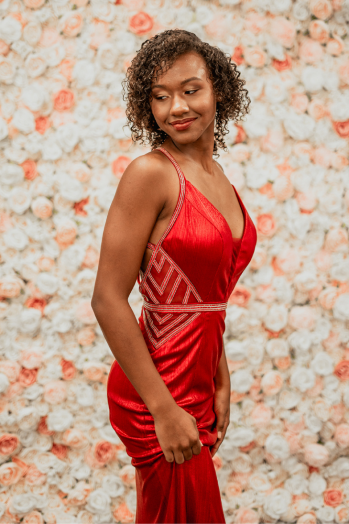Model wearing a red prom dress from our consignment prom collection, also perfect as a bold quinceanera dress option.