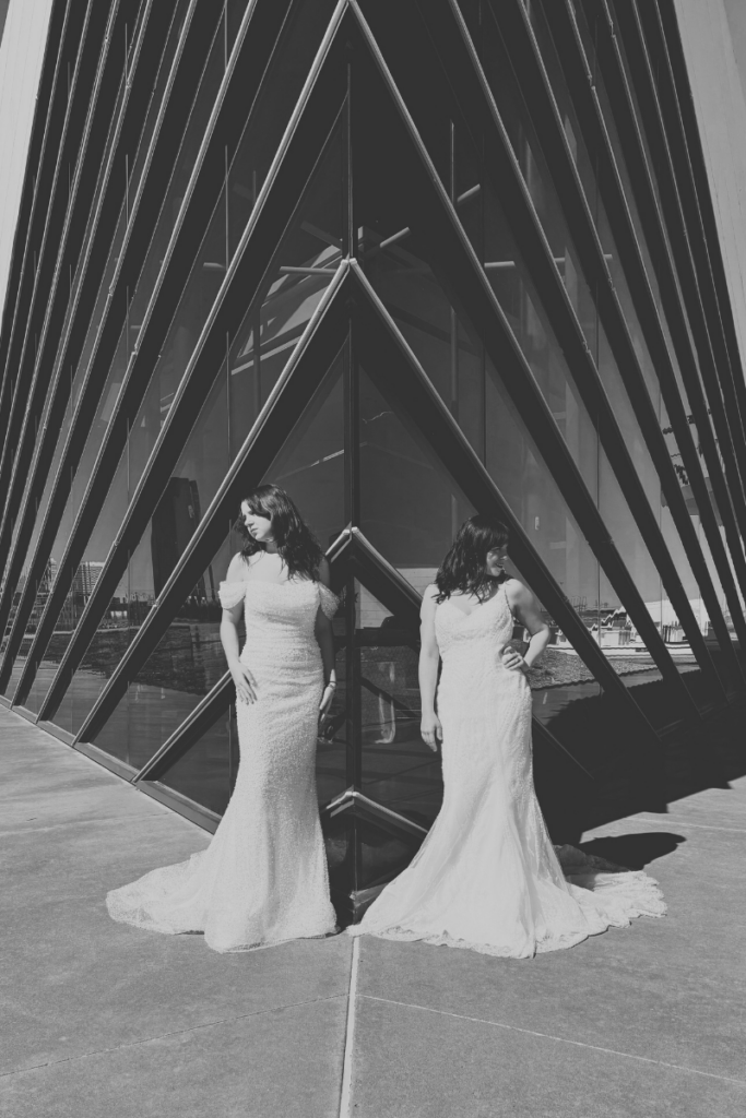 Two brides wearing fitted lace wedding dress styles from a bridal shop, showcasing expert alterations and modern elegance.