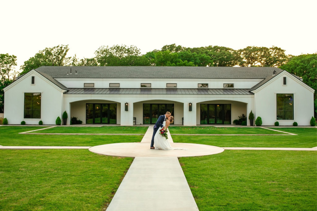 Bride and groom kissing at elegant venue after shopping bridal at a bridal boutique known for designer bridal gowns.