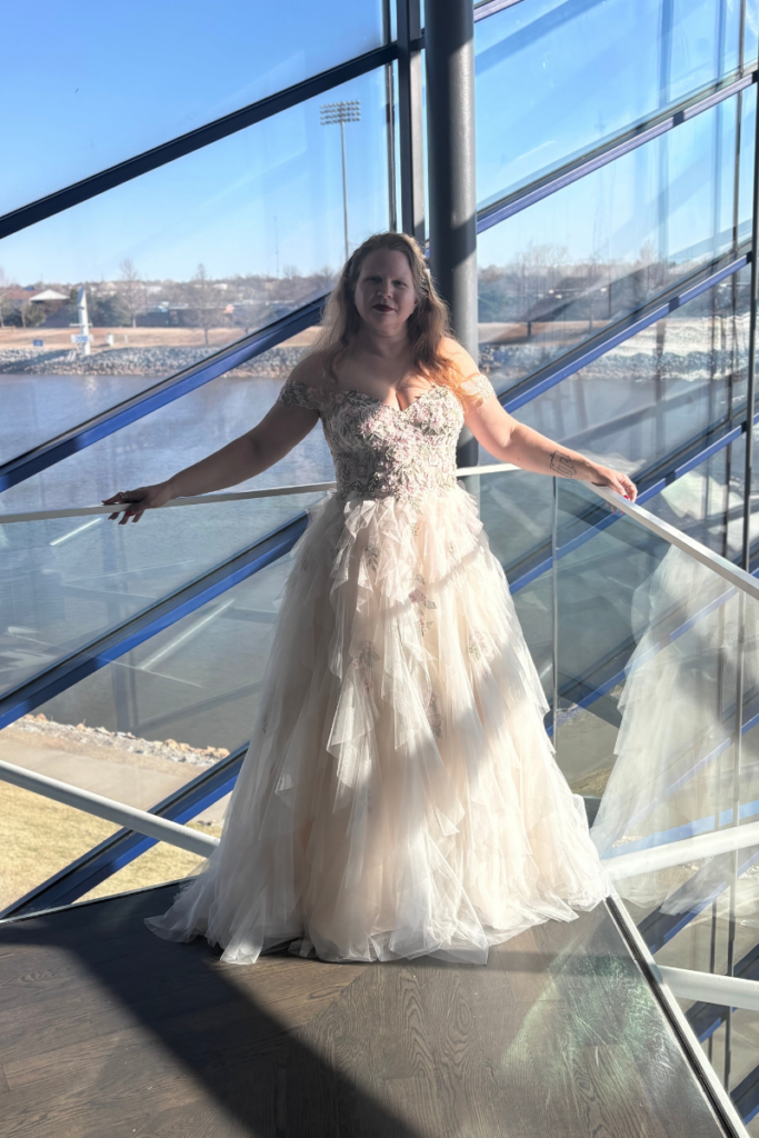 Blush quinceanera dress from our consignment prom collection, styled as a romantic prom dress with layered tulle and floral detailing.