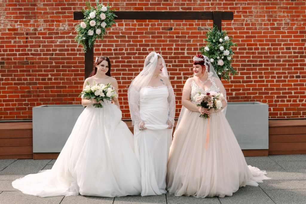 Three brides in elegant wedding gowns celebrating together with bridal tips and wedding dress advice inspiration.
