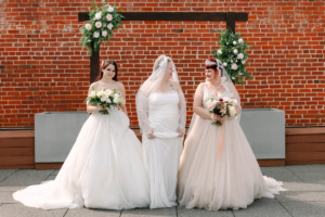 Three brides in elegant wedding gowns celebrating together with bridal tips and wedding dress advice inspiration.